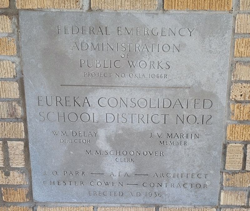 Original building plaque in picnic table cover image. Click for full size.