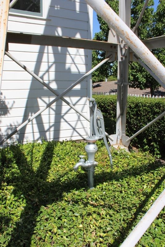Hand pump below the windmill image. Click for full size.
