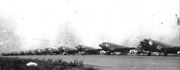 310th TCS C-47s (4A on nose) and CG-4A Waco gliders on flightline at Spanhoe, England. image. Click for full size.