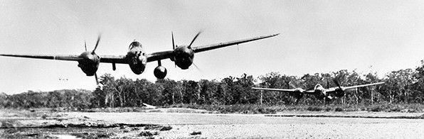 P-38 Lightnings of 39th Fighter Squadron low pass over 14-Mile Drome image. Click for full size.