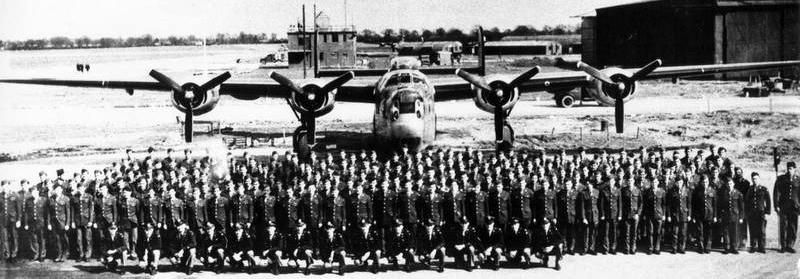 Personnel of the 489th Bomb Group with a B-24 Liberator and the control tower at Halesworth. image. Click for full size.