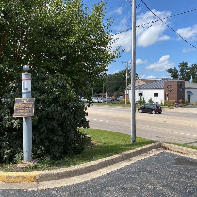 Marker located near road in parking lot image. Click for full size.