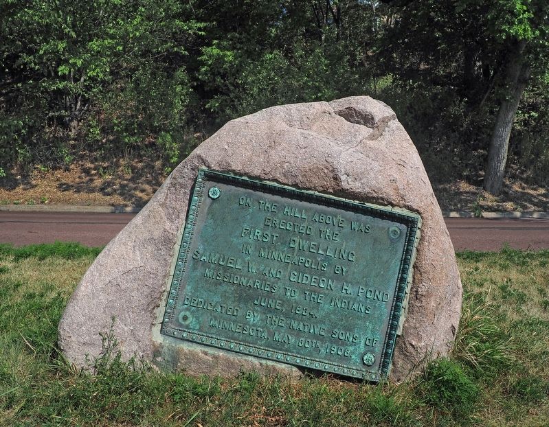 Marker mounted on a boulder that is subsiding into the ground image. Click for full size.
