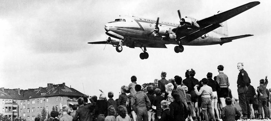 A USAF C-54 Skymaster descends into Berlin's Tempelhof Air Base as Berliners watch image. Click for full size.