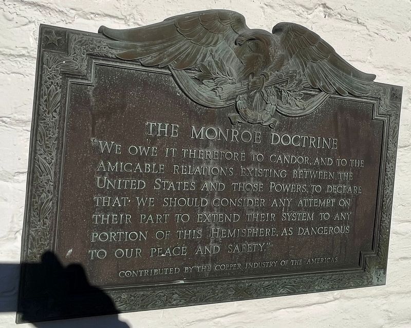 Plaque featuring the Monroe Doctrine image. Click for full size.