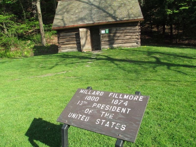 a wooden marker in front of the replicated cabin image. Click for full size.