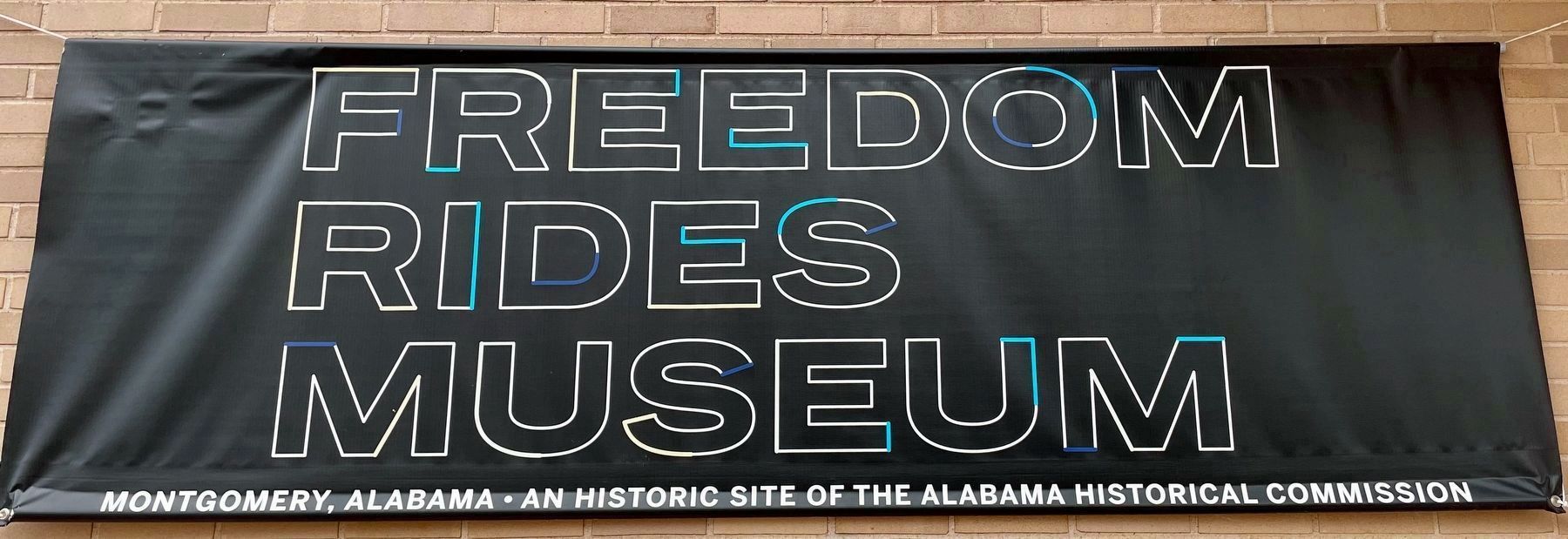 Freedom Rides Museum sign on building with markers. image. Click for full size.