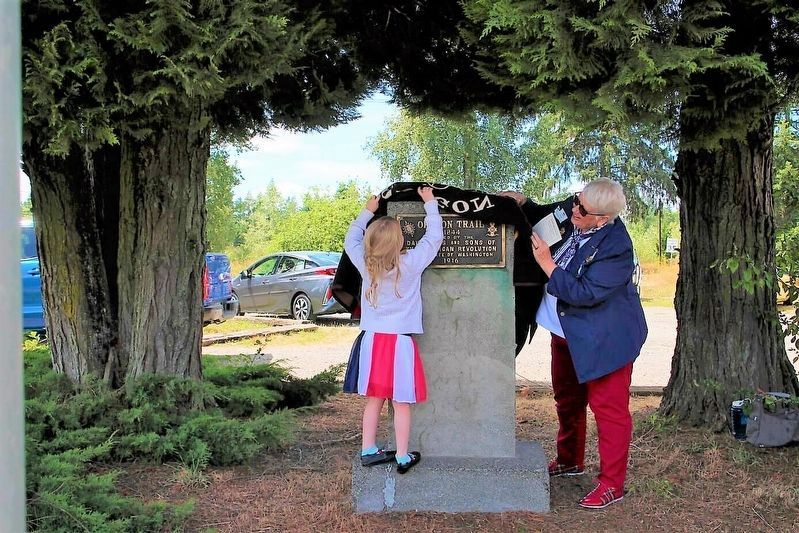 DAR member Judi Hine and her grand daughter unveil the re-dedicated marker. image. Click for full size.