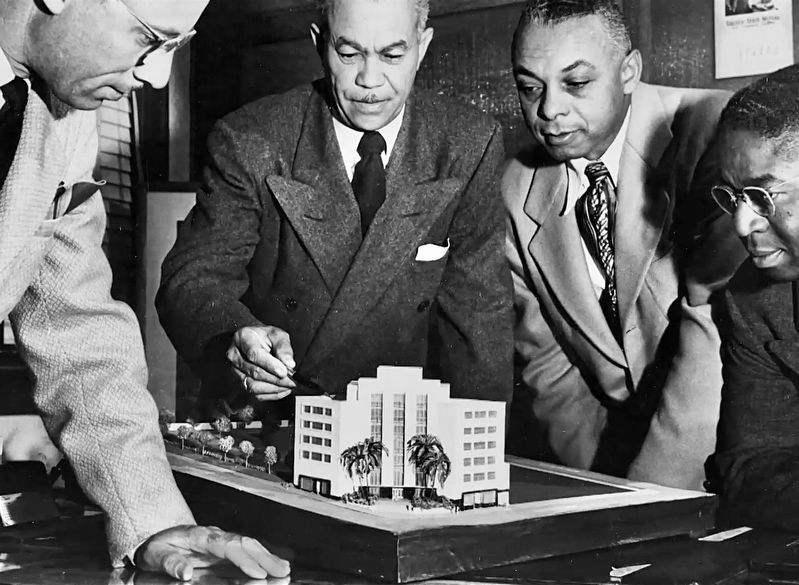 Paul Williams pointing to a building model image. Click for full size.
