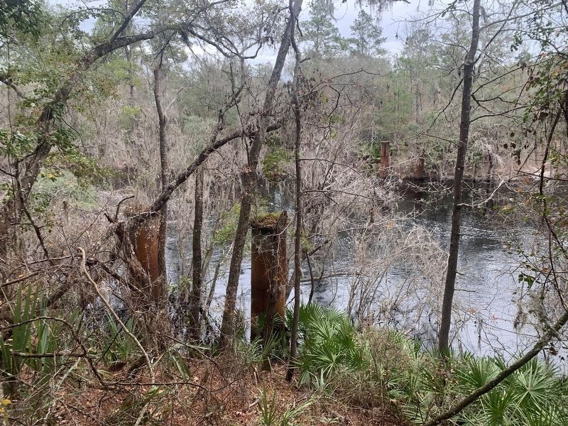 Old Godwin Bridge with pilings on both sides of the Suwannee River.. Click for full size. Old Godwin Bridge with pilings on both sides of the Suwannee River. image. Click for full size.