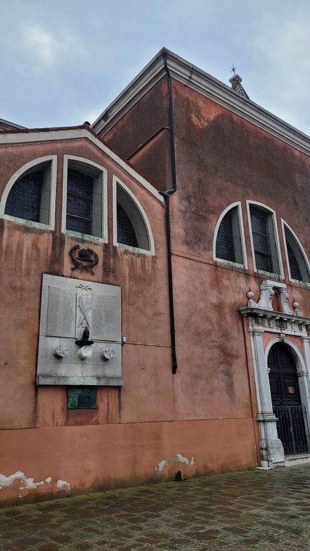 The view of the Burano War Memorial along the church wall image. Click for full size.