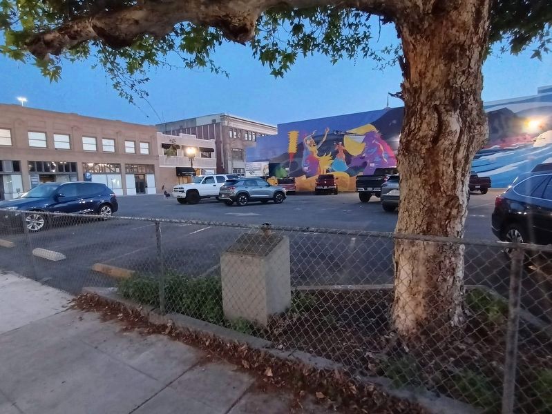 Marker is in a parking lot next to a tree and behind a fence. Click for full size. Marker is in a parking lot next to a tree and behind a fence image. Click for full size.