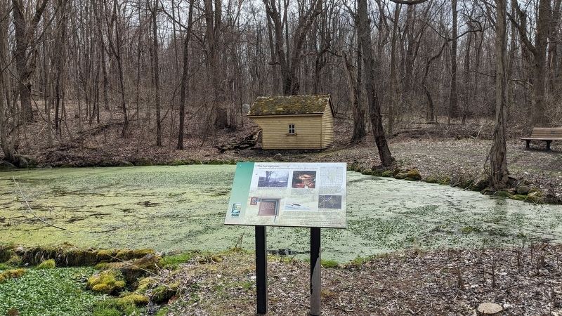 Historical marker with the springhouse. image. Click for full size.