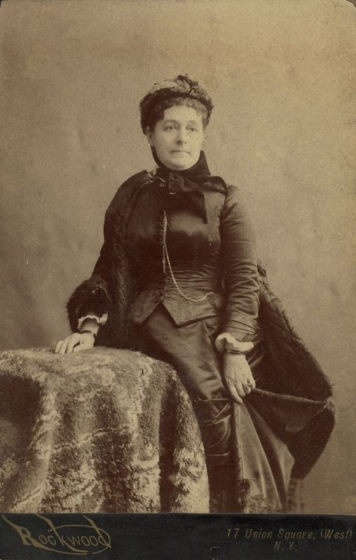 Caroline Harrison in dark dress with quilted cape. Click for full size. Caroline Harrison in dark dress with quilted cape image. Click for full size.