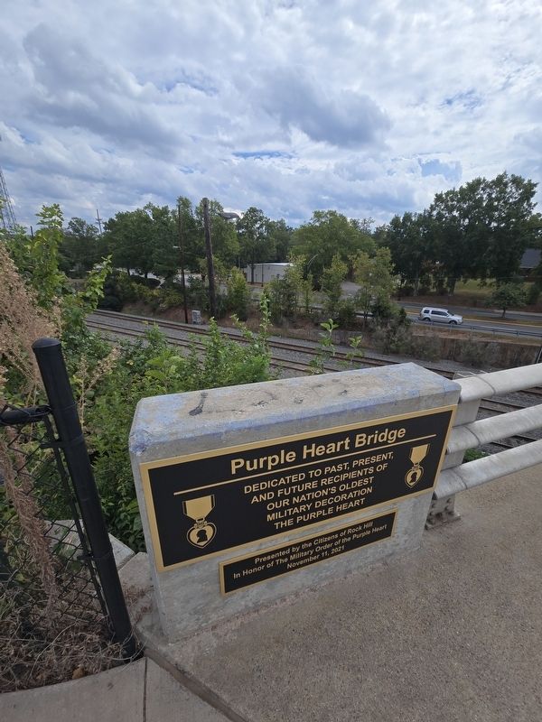 Purple Heart Bridge Marker overlooking train tracks. Click for full size. Purple Heart Bridge Marker overlooking train tracks image. Click for full size.